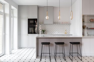 gray and white kitchen with brass fittings