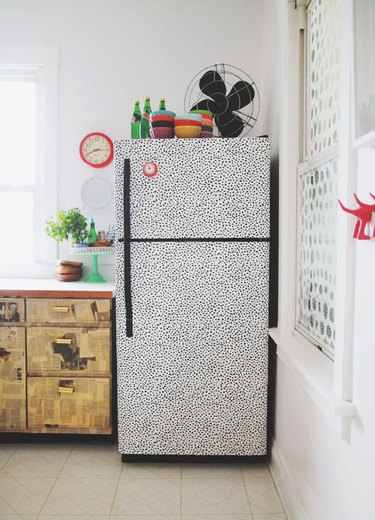 refrigerator covered in black and white spotted paper