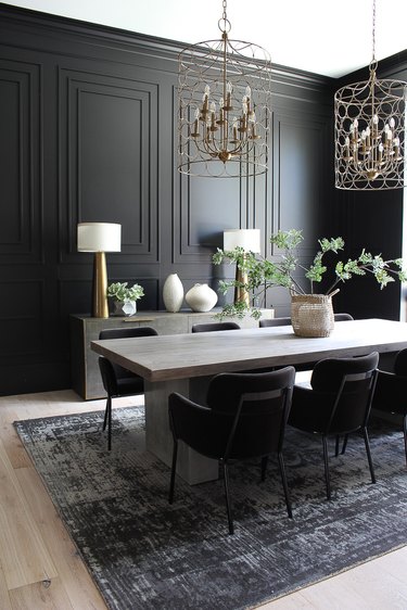 black dining room color idea with paneled walls and brass accents