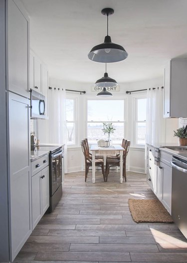 white rustic kitchen with dining nook and bay windows