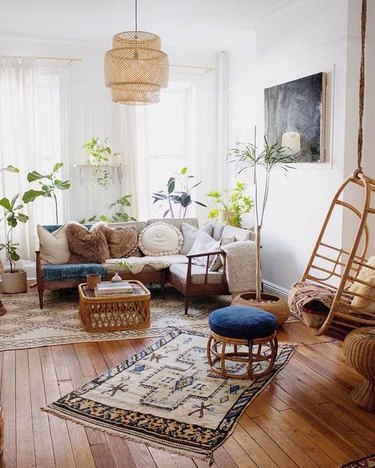 Boho living room with layered area rugs and rattan pendant light