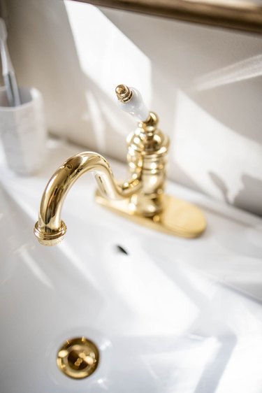 Sink with a gold sink faucet, lever handle and drain cover