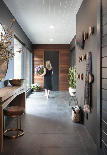 This hallway in New York brings dark and light together with wood paneling and a slate floor