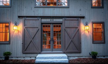 Dark wood Contemporary Barn Doors outside of modern barn house with french door entry.