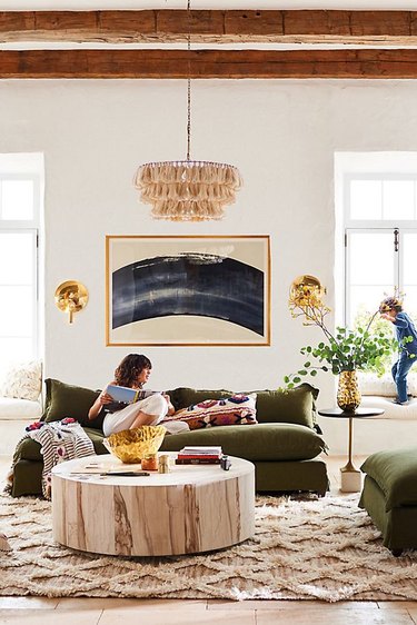 bohemian living room lighting idea with tasseled chandelier above green sofa
