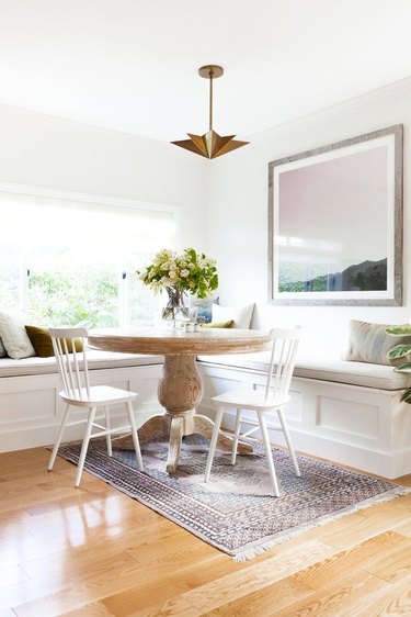 farmhouse dining room space with white chairs and white bench seating