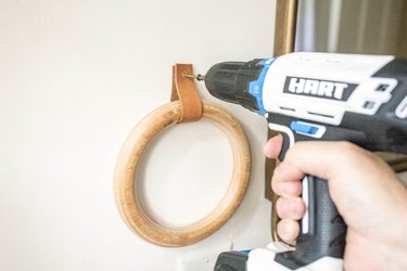 Drilling leather strip into wall to hold wooden towel ring