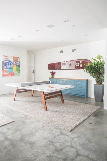 neutral garage game room ideas with table tennis and statement art
