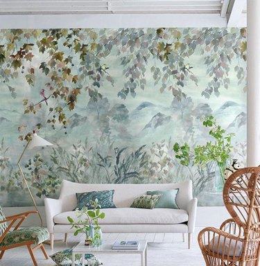 landscape mural living room wallpaper idea with white sofa and rattan chair