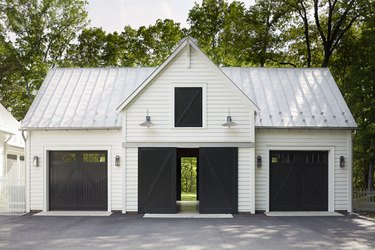 white house exterior with black carriage style garage doors