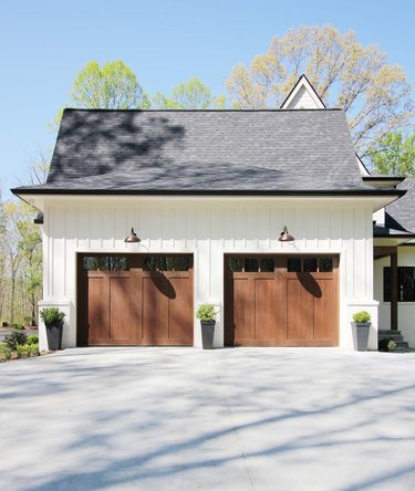 Wood barn garage doors with white farmhouse exterior