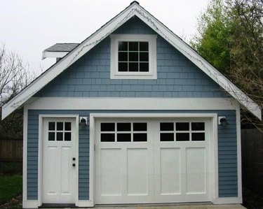 white craftsman style garage door on blue house