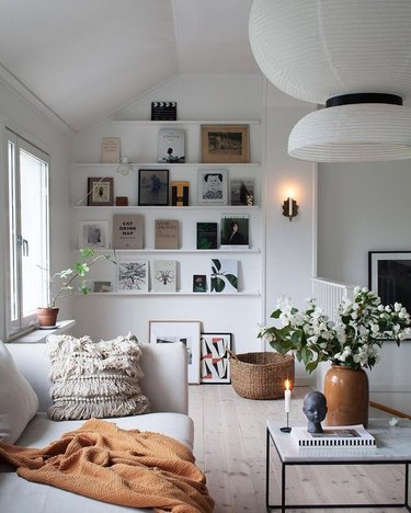 Scandinavian living room with open shelving and statement chandelier