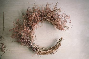 Top half of crescent wreath filled with dried floral bundles