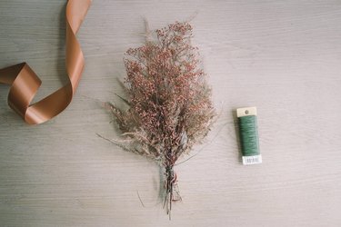 Dried gypsophilia and feather fern tied into a bundle with floral wire