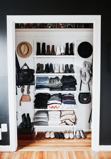 Reach-In bedroom closet idea by Meg Biram with open shelving and wall hooks