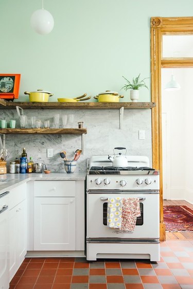 mint green kitchen with retro stove and checkered tiles