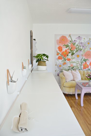 Garage office with floral wall mural and white workstations