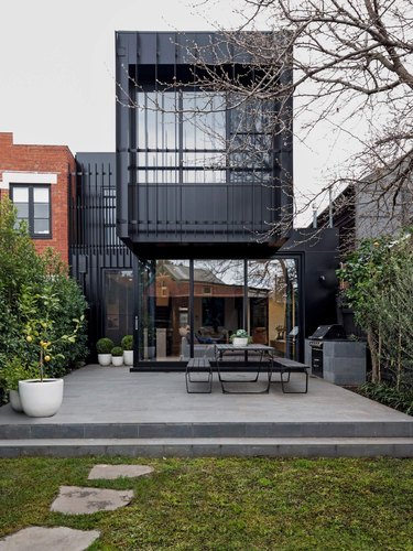 black contemporary home exterior idea with outdoor seating
