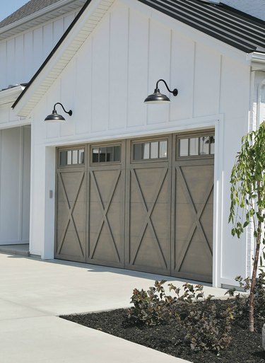 Light gray wood barn garage doors with X design and barn lights