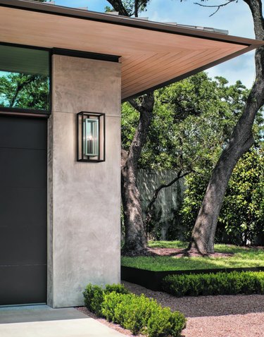 Contemporary home exterior with modern outdoor sconce and black garage door