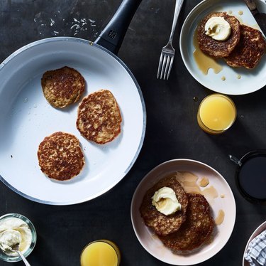 Ceramic pans with pancakes and plates with pancakes.