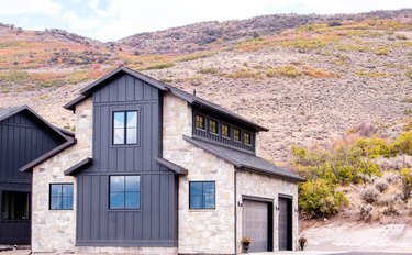 Contemporary home exterior with stonework and siding in mountain landscape