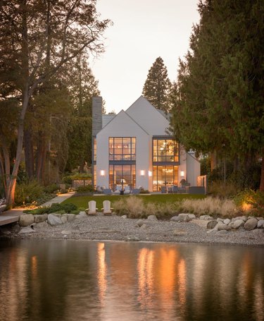 Contemporary home exterior next to lake with large windows