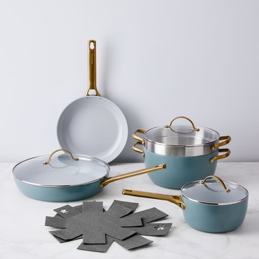 Teal ceramic cookware set with brass handles