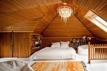 wood-clad walled bedroom with chandelier for bonus room above garage idea