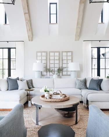 living room sectional with white sofa and back cushions and blue throw pillows