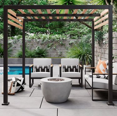 Black contemporary pergola next to pool with outdoor fireplace