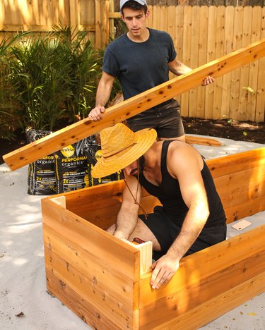 men building wooden garden beds