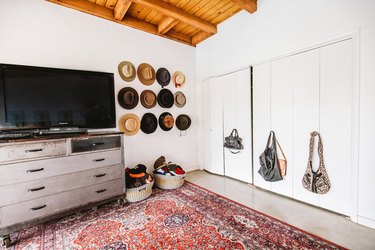 Attic Closet Ideas with bifold closet, printed rug, and dresser