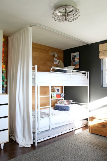 bedroom with white bunk beds and black accent wall