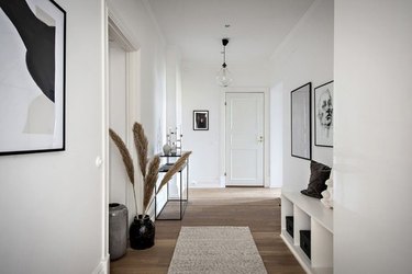 hallway with framed art, bench, and plant