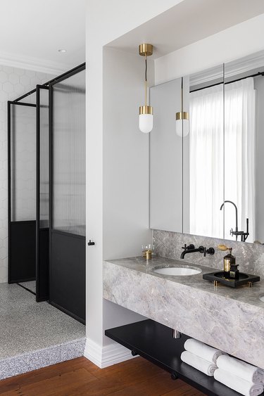 white modern bathroom with glass shower door and gray marble vanity