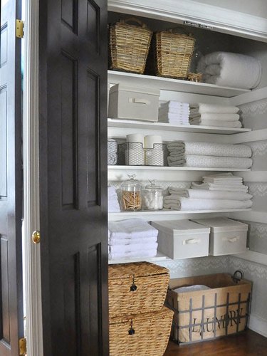 linen closet organization with open and closed containers and bins