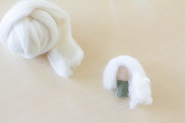 Gluing wool roving on top of wooden bead