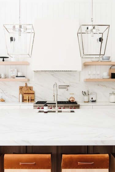 white marble chef's kitchen with gooseneck kitchen faucet with undermount kitchen sink and pot filler at stove