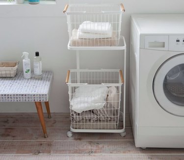 Garage Laundry Room with Front load washer, moveable two tiered laundry rack, low tile table.