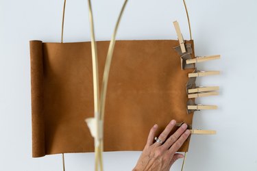 DIY magazine rack using gold hoops and leather