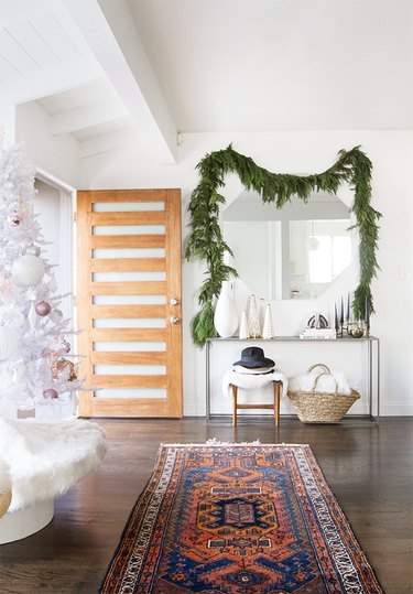 entryway with garland hung above mirror