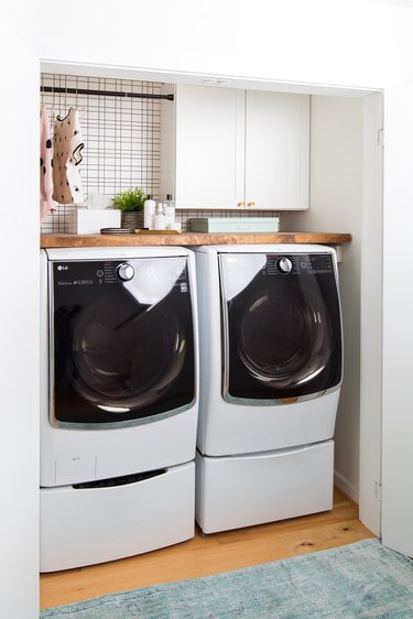 small basement laundry room ideas with white washer and dryer in a closet.