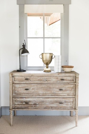 Wood dresser in French country bedroom near window