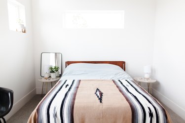 Bed with desert-style blanket and white walls