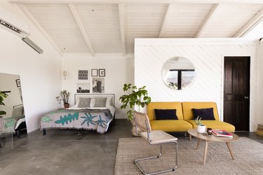 bedroom and accent chairs and concrete flooring