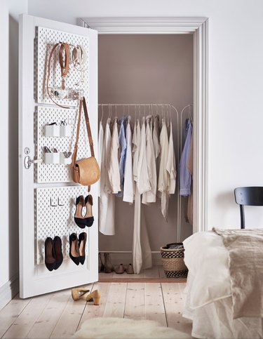 bedroom closet storage idea with shoe rack on door and clothes rack