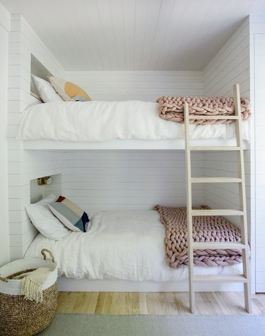 all white bedroom with shiplap walls and chunky knit bed throws