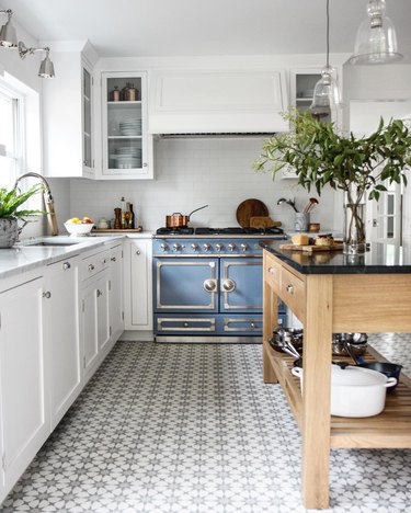 vintage kitchen appliances with patterned floor tile and white cabinets